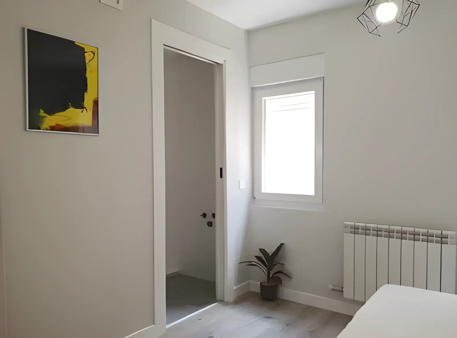 Habitación recién pintada en blanco por Los Pintores Alcala de Henares para comunidad de vecinos