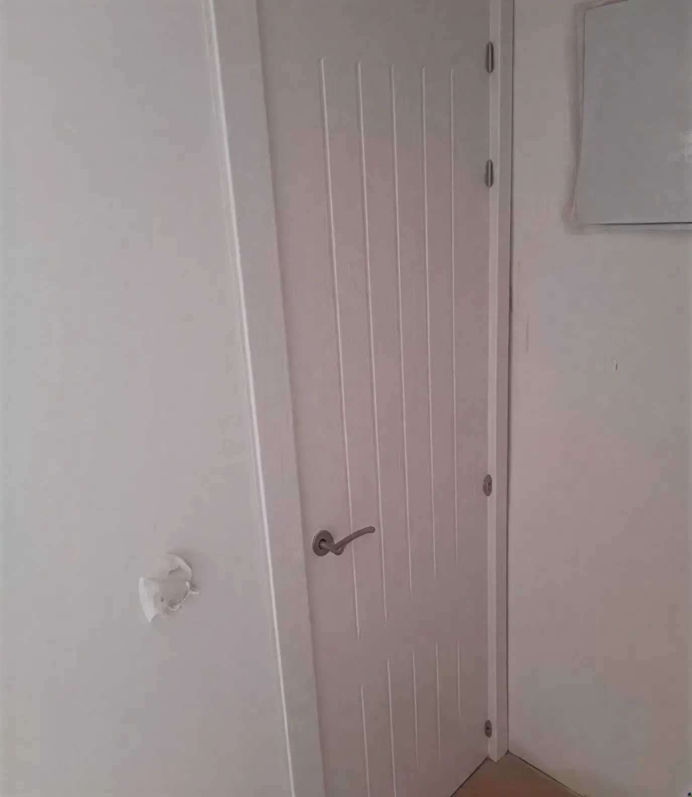 Puerta moderna con ranuras lacada en blanco por pintores profesionales en Alcalá de Henares